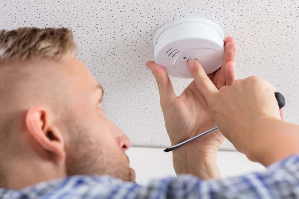 technician testing smoke alarm