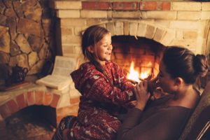 mother and daughter next to a fire place